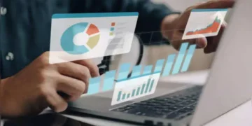 Professional analyzing financial growth charts on a laptop, reflecting a strong money mindset.