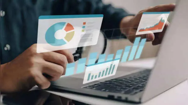 Professional analyzing financial growth charts on a laptop, reflecting a strong money mindset.